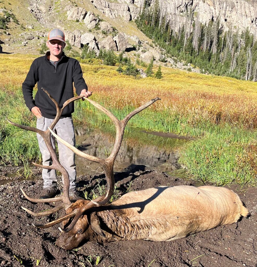 Owner of the company, Justin, stands with a harvested bull elk